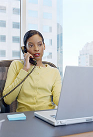 Businesswoman on the telephone while working on a laptop